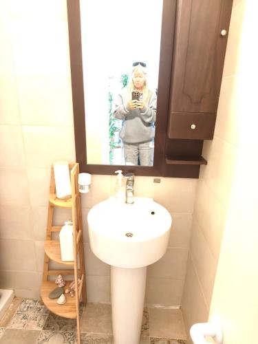 a woman taking a picture in a bathroom mirror at Danit apartmnt by the sea in Zygi