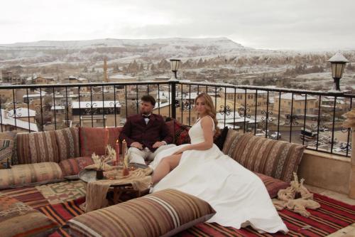 a bride and groom sitting on a couch at Kismet Cave Mansion in Göreme