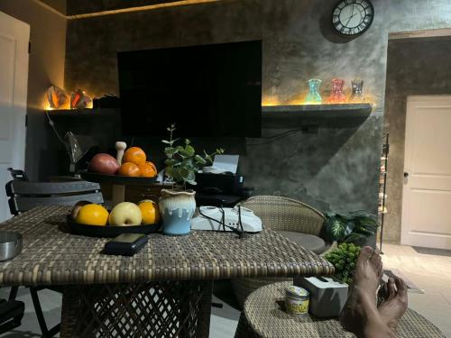 a person with their feet on a table with fruit at Sla guest house in Boracay