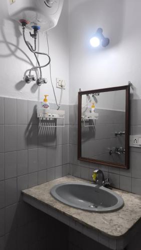 a bathroom with a sink and a mirror at Royal Inn in Lucknow