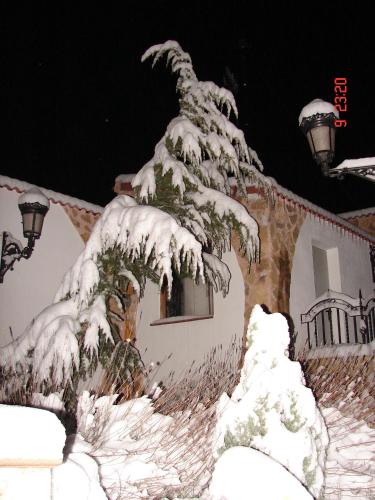 a tree covered in snow in front of a house at La Hacienda de mi Señor in Lerma