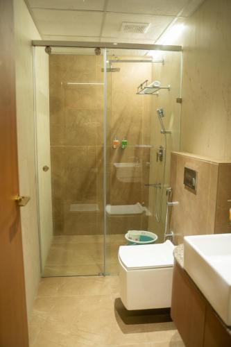 a bathroom with a shower with a toilet and a sink at AAA URBAN STAY-Madhapur in Hyderabad