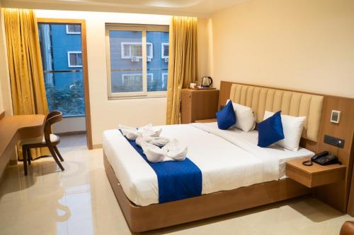 a bedroom with a large bed with blue and white pillows at AAA URBAN STAY-Madhapur in Hyderabad