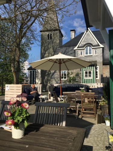 a man sitting on a bench under an umbrella at Landfein Big Country House in Winterberg