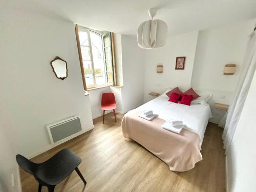 a bedroom with a white bed and a red chair at Le Mandragot - Séjour en Aspe in Bedous