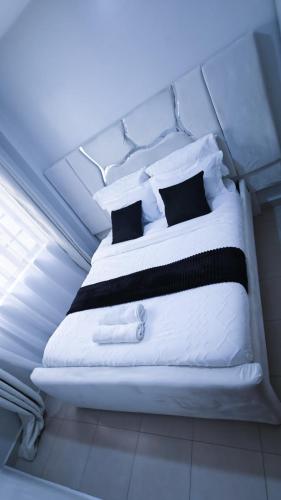 a white bed with black pillows in a room at EBM Homes in Nairobi