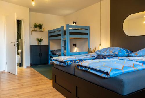 two beds in a bedroom with blue bunk beds at Modern Western - Apartment Blue in Eging
