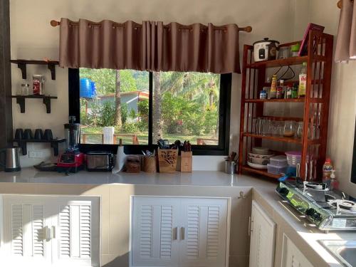 a kitchen with a window and a counter top at Baan Mada Lanta villa in Ko Lanta
