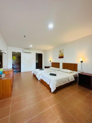 a large bedroom with two beds and a television at Landcons Hotel & Resort in Pantai Cenang