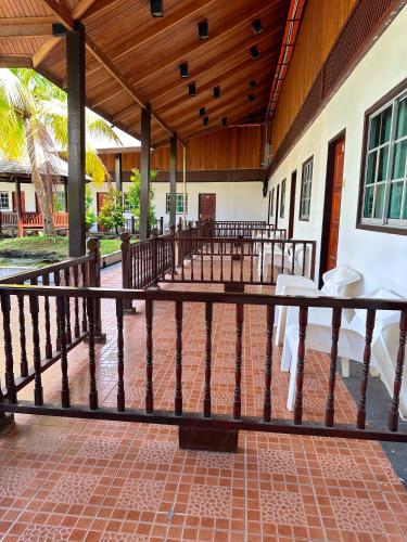 a porch of a house with a wooden fence at Landcons Hotel & Resort in Pantai Cenang