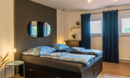 a bedroom with a bed with blue pillows and a mirror at Modern Western - Apartment Blue in Eging