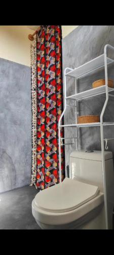 a bathroom with a toilet and a shower curtain at Sunset Lover in Michamvi