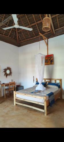 a bed in a room with a ceiling at Sunset Lover in Michamvi