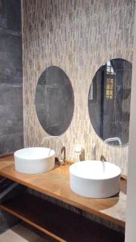 two sinks in a bathroom with two mirrors at Luxury Private Villa with Pool in The Gambia in Sambuya