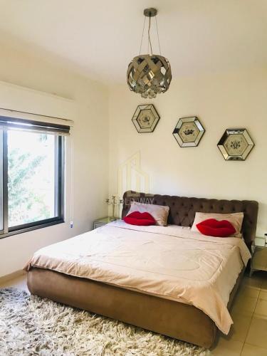 a bedroom with a large bed with red pillows on it at Chic 2-Bedroom - Fully Furnished in Amman