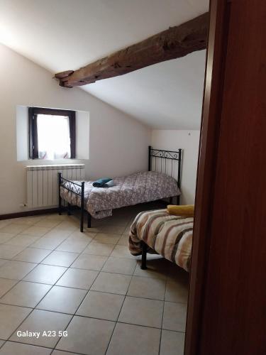 a bedroom with two beds and a window at La corte dei celti 9 in Quinzano