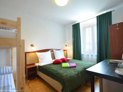 シフィノウイシチェにあるMoniuszki24のベッドルーム1室(緑のシーツと赤い枕が備わるベッド1台付)