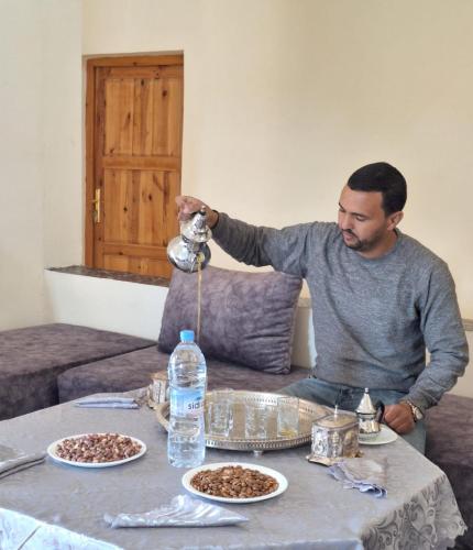 a man holding up a camera at a table with food at Kasbah Anisi in Irhels