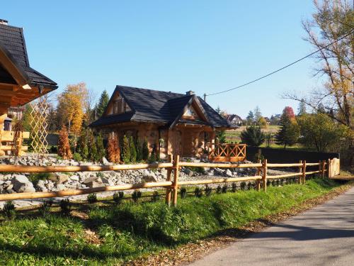 a wooden fence in front of a house at Chata w Rabce - Bajkowa Osada in Rabka