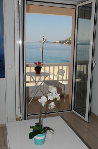 a room with a balcony with a view of the ocean at Sunset by the sea 1 in Loutraki