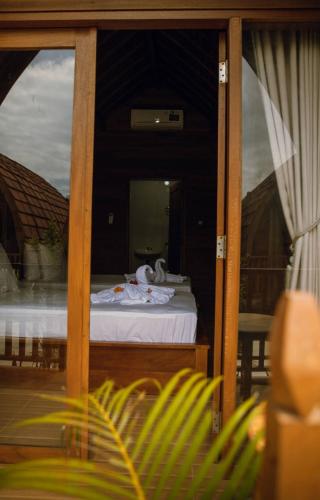 a view of a bedroom with a bed and a mirror at Lokasea Villa Bali in Pengastulan