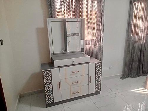 une télévision posée sur une commode dans une chambre dans l'établissement Villa afia, à La Somone
