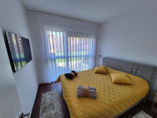 a bedroom with a yellow bed and a window at Avram in Vrnjci