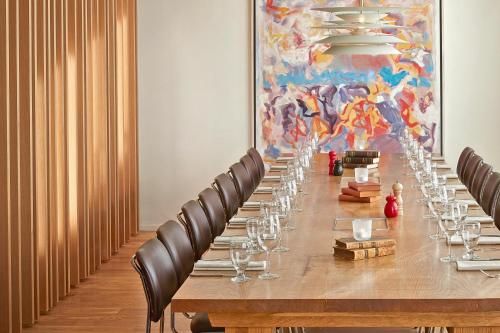 a long table in a room with chairs and a painting at Reykjavik Natura - Berjaya Iceland Hotels in Reykjavík