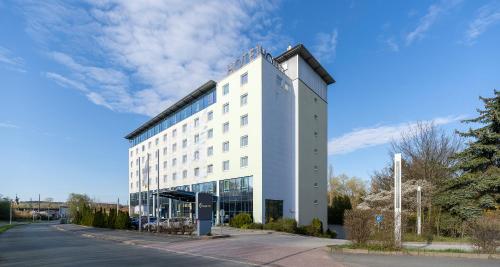 a large white building on the side of a street at PLAZA INN Zwickau in Zwickau