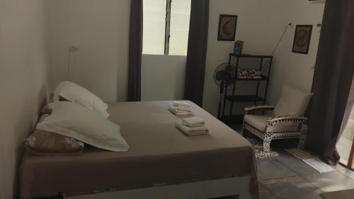 a bedroom with a bed and a chair and a window at Huahine's Place in HUH