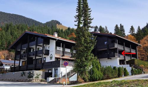 a large building with a tree in front of it at Apartment am Spitzingsee in Spitzingsee