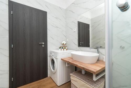 a bathroom with a sink and a washing machine at Runaway Cottage in Unešić