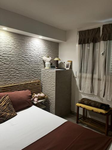 a bedroom with a bed and a brick wall at The Incantation Guest House in Montesilvano