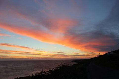 a sunset over the ocean with a cloudy sky at Clifden Bay Lodge in Clifden
