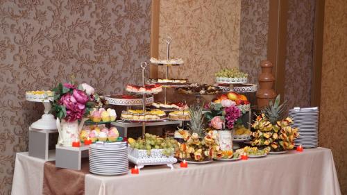 uma mesa com um buffet de frutas e sobremesas em Marigab em Turceni