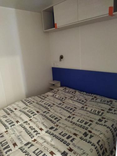 chalet 2 في Saint-Christol-lès-Alès: غرفة نوم بها سرير مغطى بغطاء سرير أزرق وأبيض