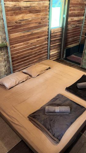 a large bed in a room with a wooden wall at ALAMSUKA Cikole in Tangkubanperahu