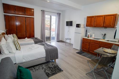 a bedroom with a bed and a kitchen with a refrigerator at Mountain View Star in Estreito da Calheta