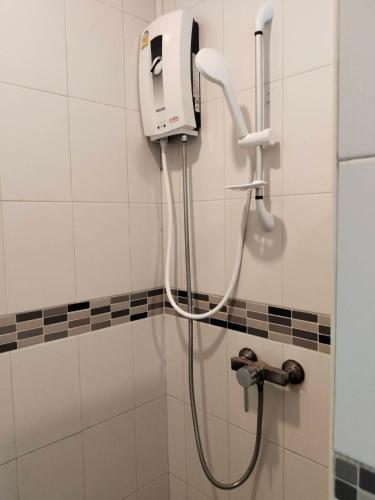 a shower in a bathroom with a hand dryer on the wall at Bedroom301 Kata Beach Phuket in Kata Beach