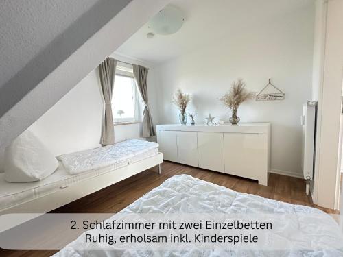 a white bedroom with a bed and a window at Moderne Ferienwohnung in Strandnähe - Urlaubsträume am Meer in Neue Tiefe Fehmarn