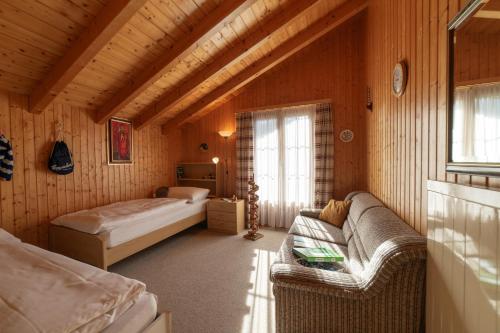 a bedroom with a couch and a bed in a room at Sonnegge in Wildhaus