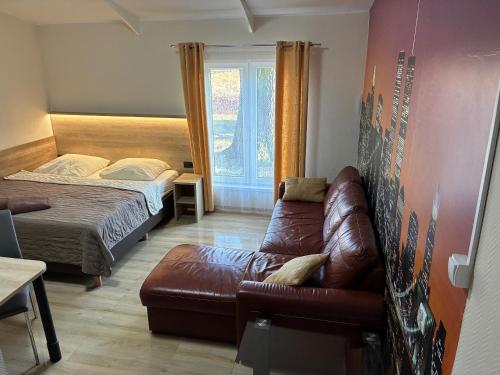 a living room with a couch and a bed at Apartamenty przy Obrze in Skwierzyna