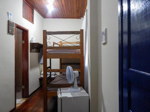a small room with a bunk bed with a fan at Casa de Mariazinha in Ouro Preto