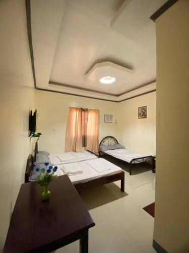 a room with two beds and a table in it at BICAMM Inn in Sampong