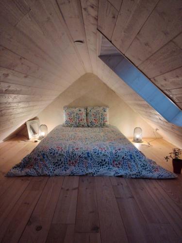 a bedroom with a bed with a wooden floor at Ti Forn - Les fours à pain in Dinéault