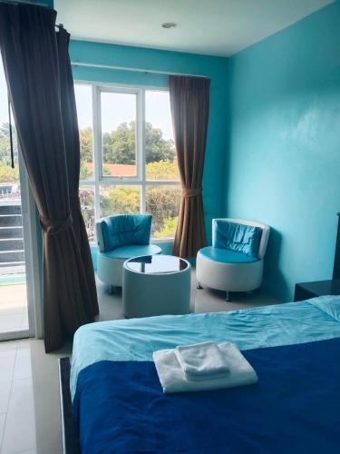 a bedroom with a bed and two chairs and a window at Bedroom401 Kata Beach Phuket in Kata Beach