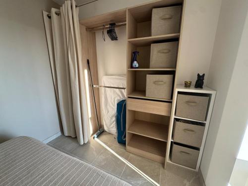una habitación con un armario con cajas y una cama en La maisonnette, en Montblanc