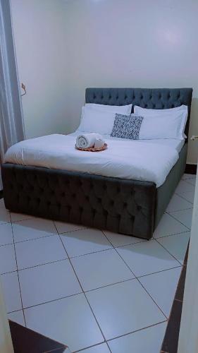 a bed sitting on a tiled floor in a room at Amani Home in Kisii