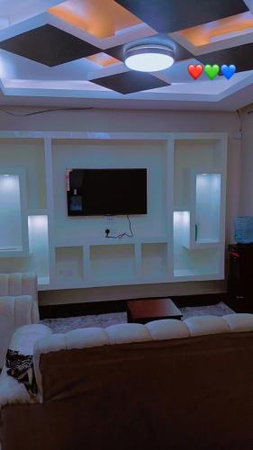 a living room with a couch and a flat screen tv at Amani Home in Kisii