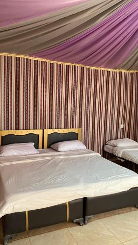 a room with two beds in a tent at Golden Camp- wadi rum in Wadi Rum